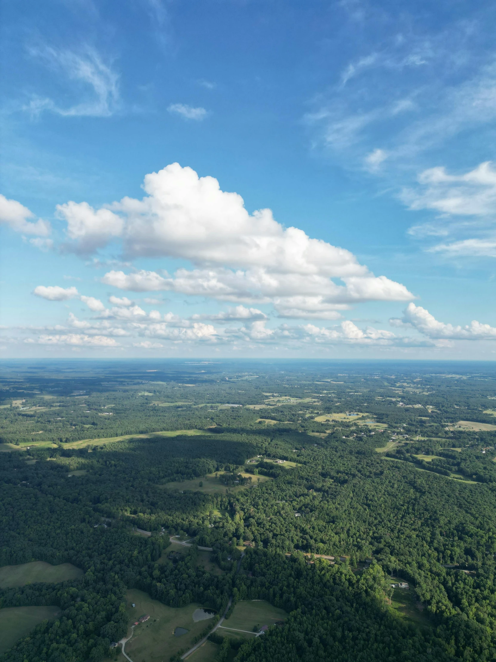 a view from above of an area with rolling green trees and a river