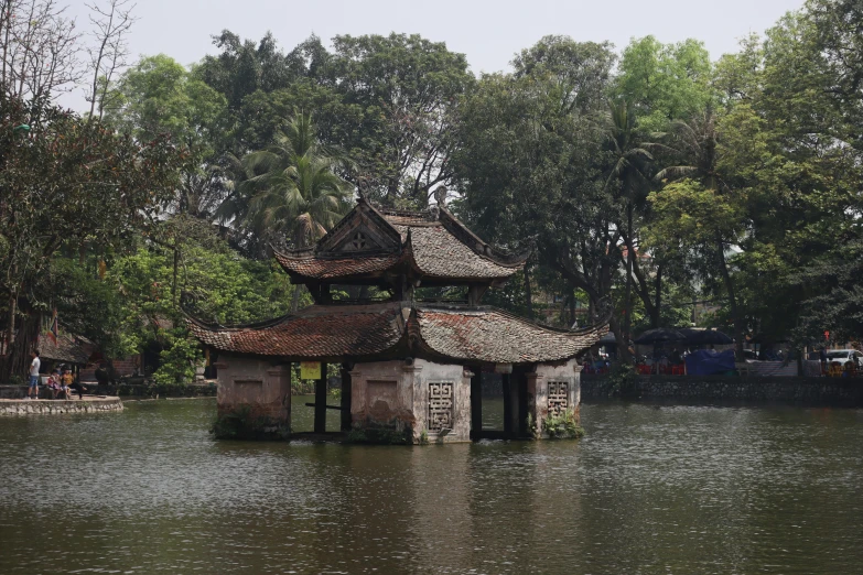 a building floating in a lake next to a forest