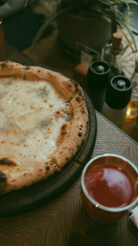 the pizza with cheese is on the table near the ketchup