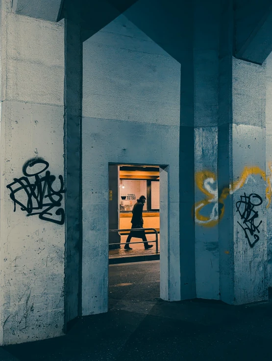 a person walking into a building doorway with graffiti
