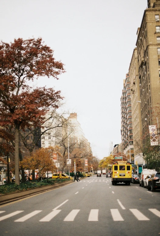 the view from a cross walk with a van going down it