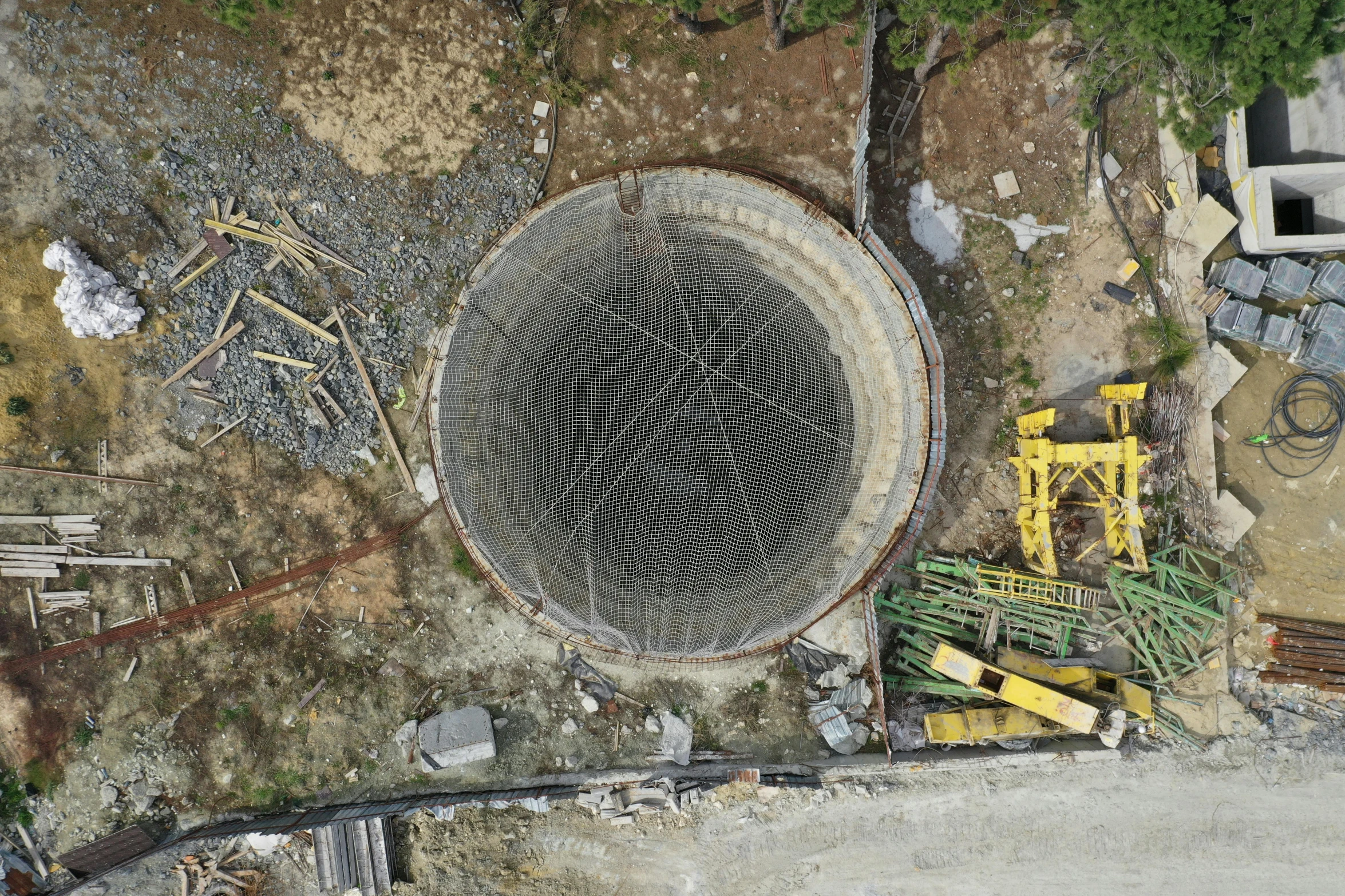 an old drain in a park surrounded by construction work