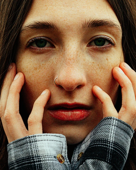 a close - up po of a woman holding her hands near her face