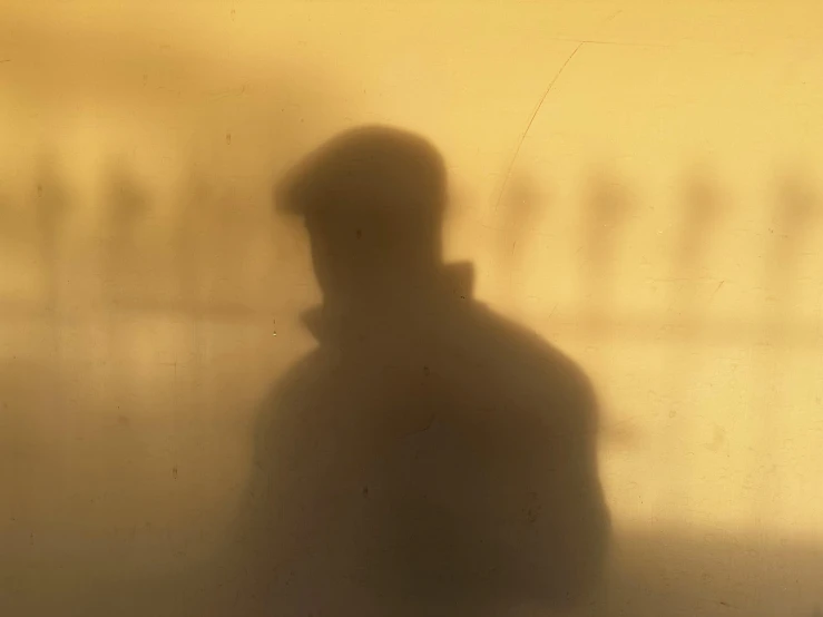 a shadow of a person with a hat on a wall