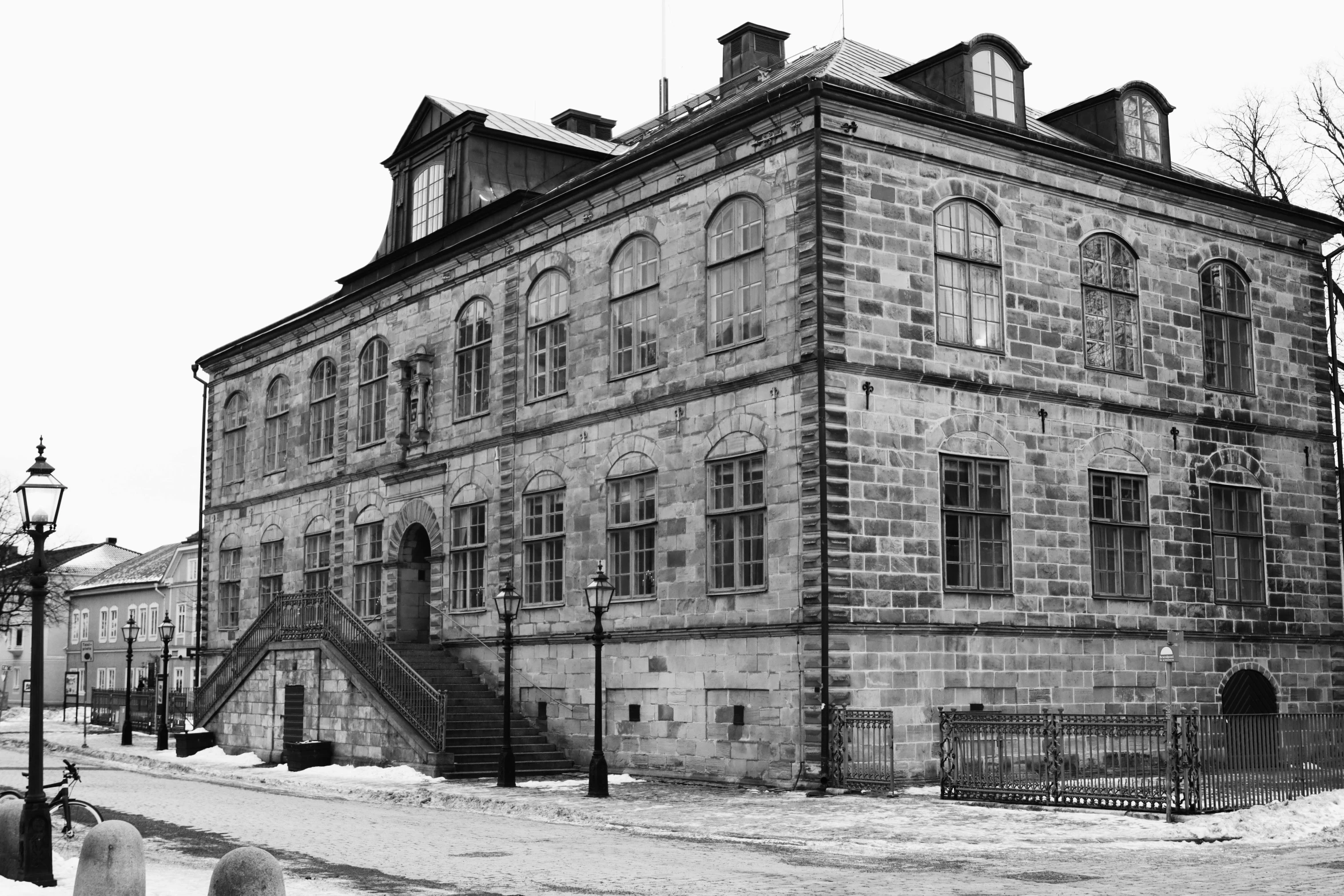 an old stone building with some windows and a fence