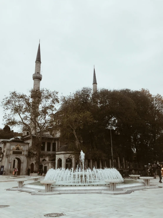 the fountains are on display with large trees behind them