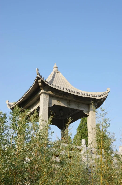 a stone structure near some trees under a clear blue sky