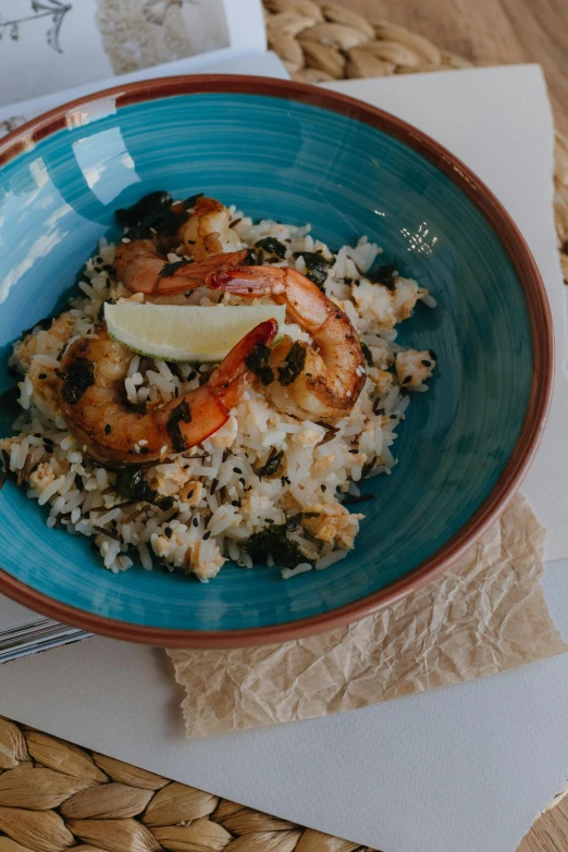 a blue bowl filled with food on top of a wooden table