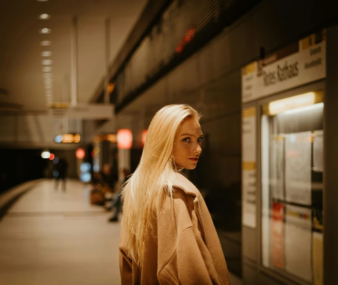 blonde woman standing in the middle of an empty train station