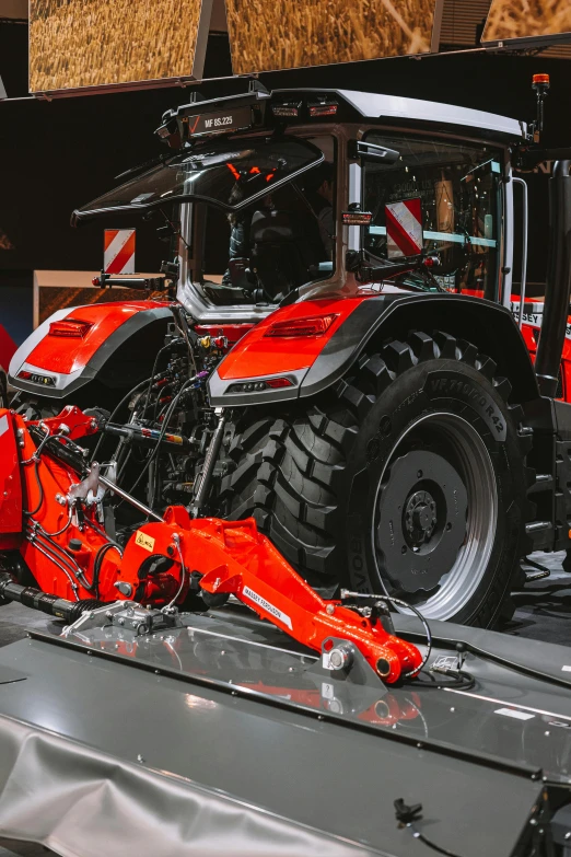 a red tractor that is parked in a showroom