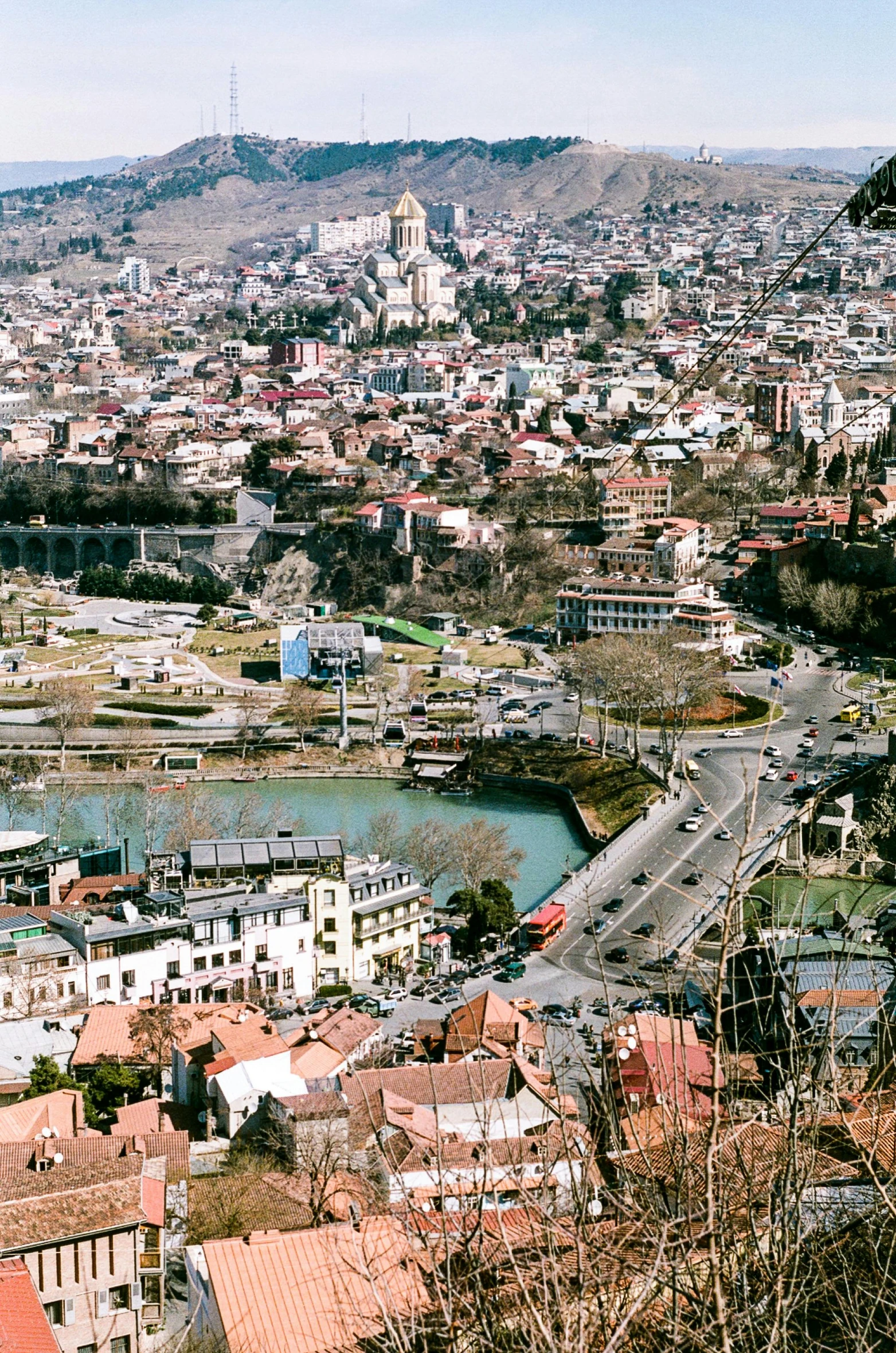 a city view taken from atop a hill with lots of buildings