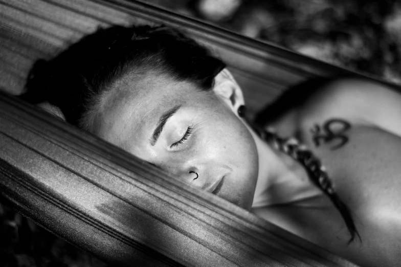 a woman laying in a hammock on top of the ground