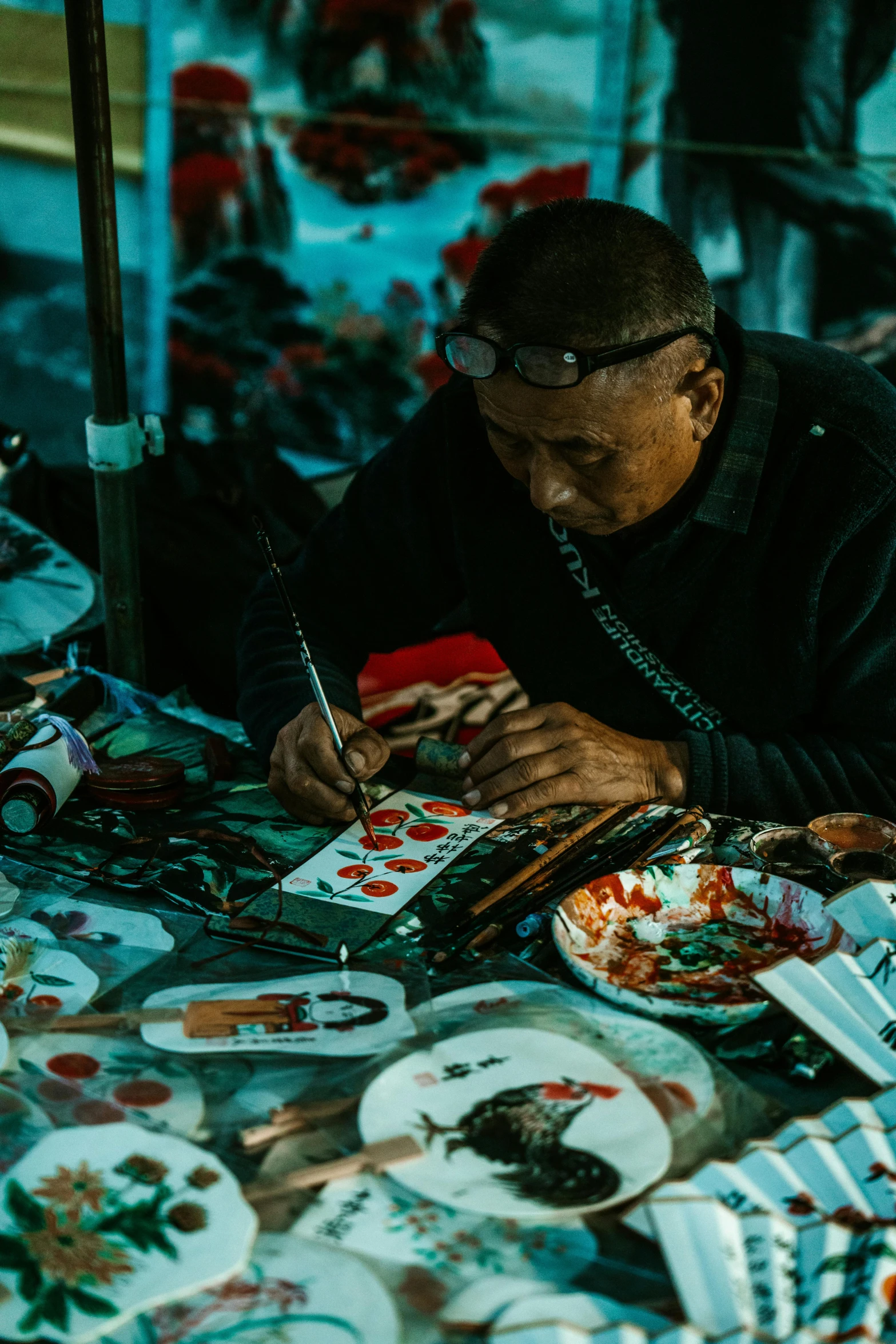 man with a phone and glasses next to a table full of plates