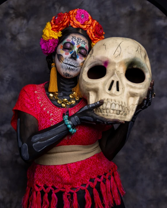 a woman in red with a fake skull on her arm