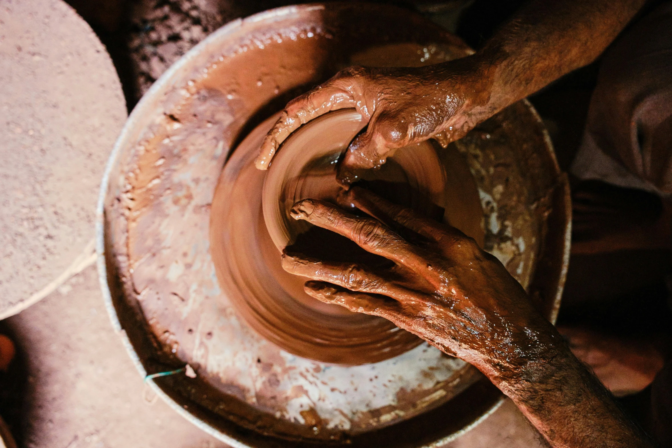 some hands that are over some pottery