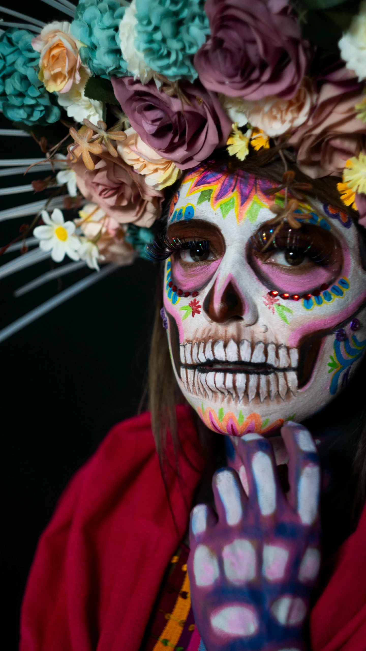 a woman with makeup painted in colors of skulls and flowers