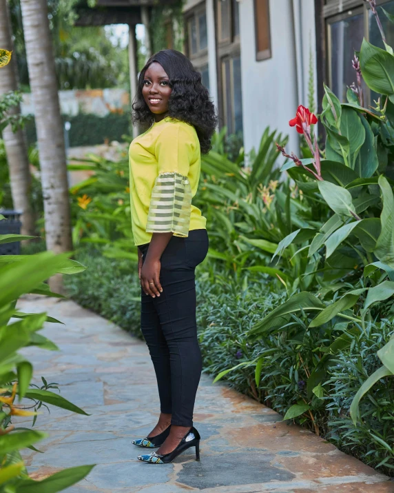 the young woman smiles at the camera in her black and yellow outfit