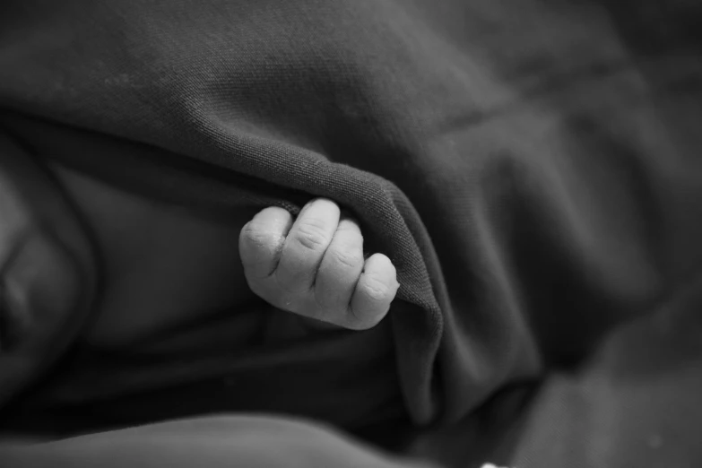 a hand on a blanket holding the top of it