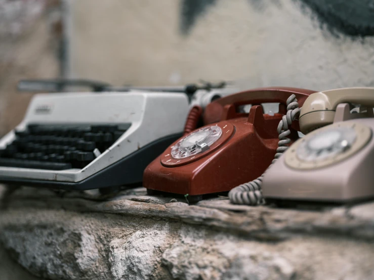 there is a typewriter, telephone and a typewriter sitting on a ledge