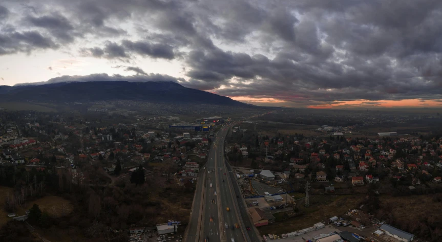 a city surrounded by trees under a cloudy sky