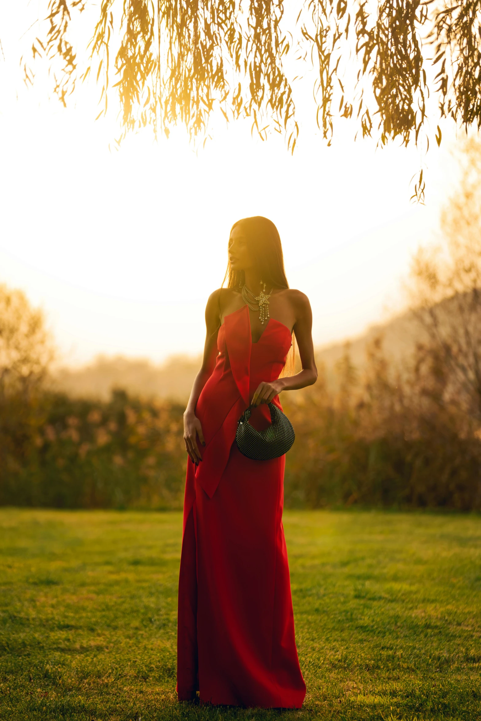 a beautiful woman in a red dress looking back at her purse