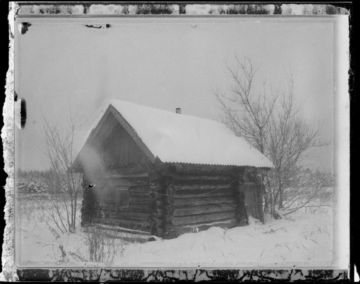 a cabin on a snowy field in a field