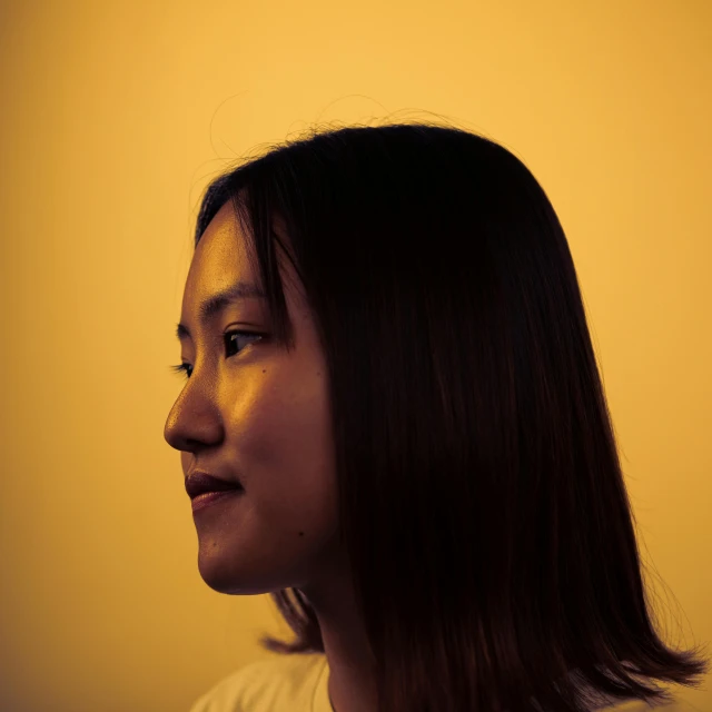 a woman wearing an orange and white shirt looks away