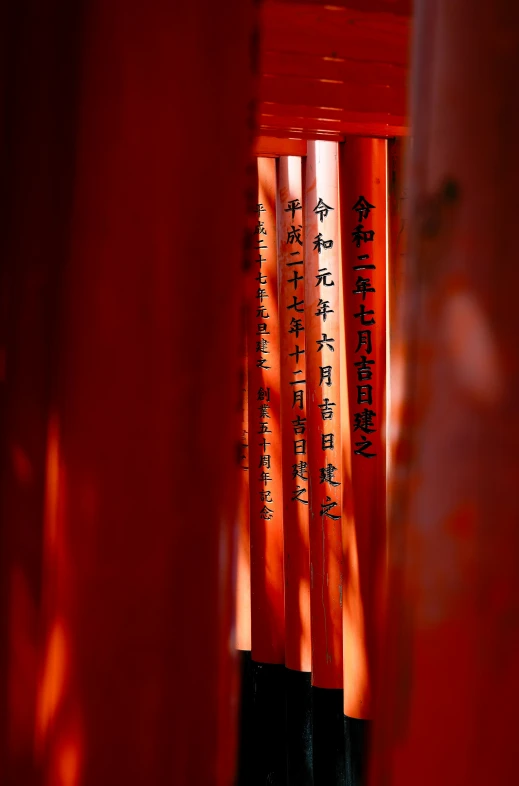 three tall red poles with asian writing on them