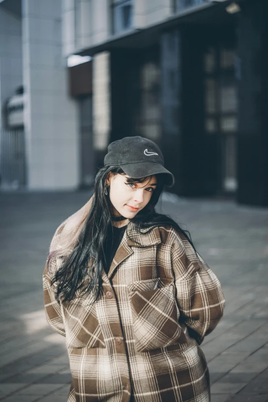 a woman with long black hair is wearing a jacket and a hat