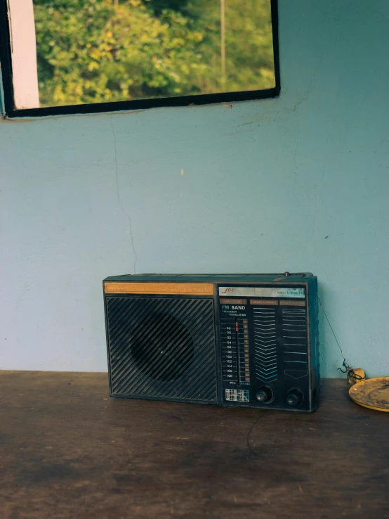 an old radio and a banana sitting on a table in front of a window