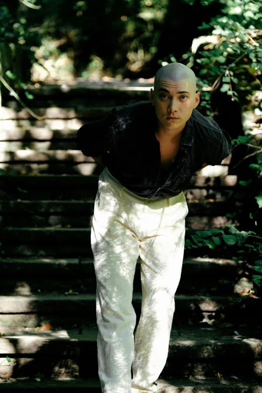 a man in white pants and jacket walking down steps