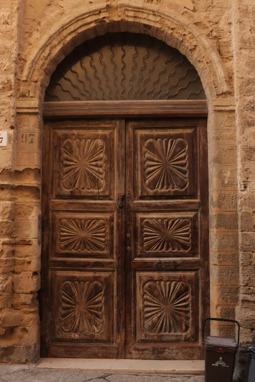 large brown wood door with fancyly carved carvings