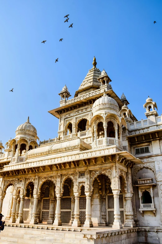 a white marble temple with birds flying around