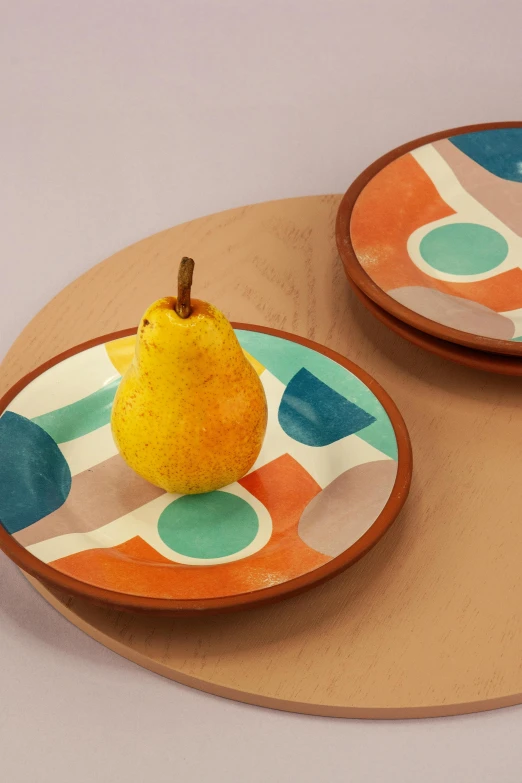 two small, brightly colored plates with an apple on one