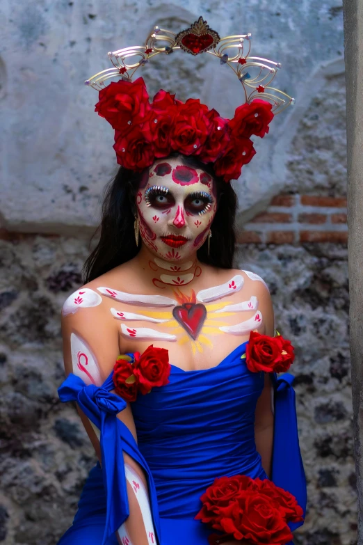an attractive woman with her face painted as skeletons, holding flowers