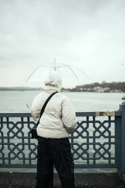 a man standing on a sidewalk with a snow covered umbrella