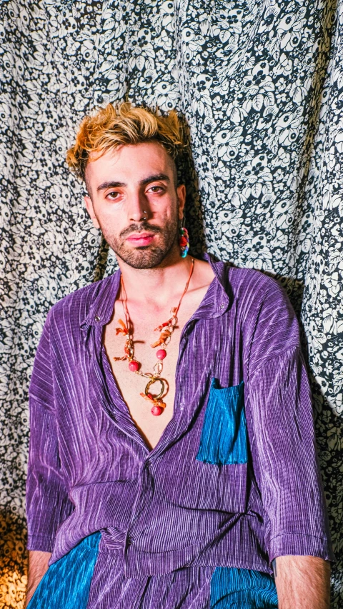 a man with a necklace and shirt on