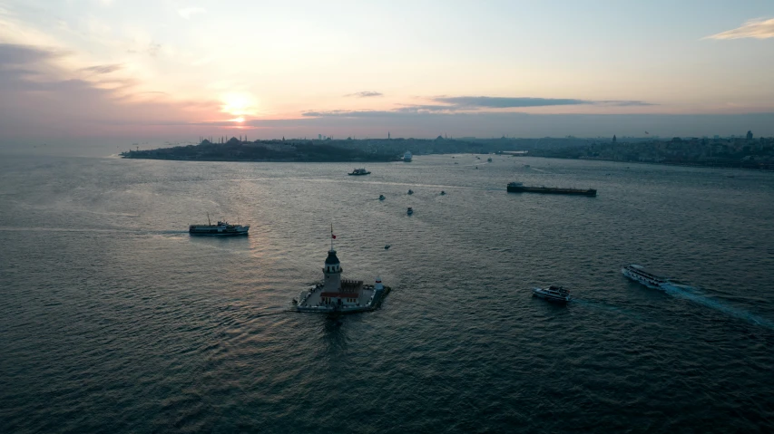 a ship sailing in the ocean as the sun sets