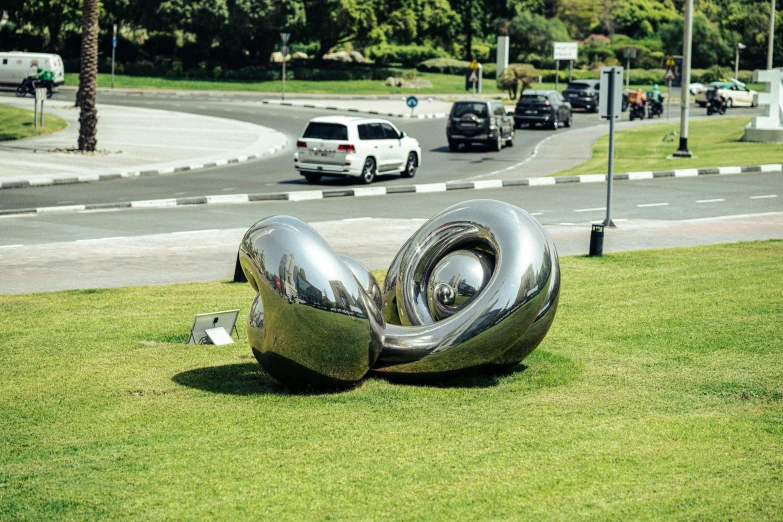 an artistic sculpture on a lawn, made to look like the letters s