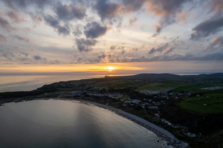 a beautiful sunset over a small town on the beach