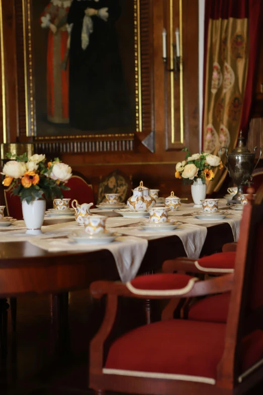 an elegant setting of table with flowers and teacups on it