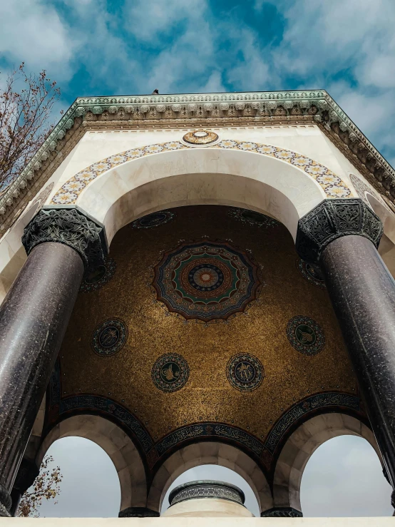 an architectural arch is in the background under some blue skies