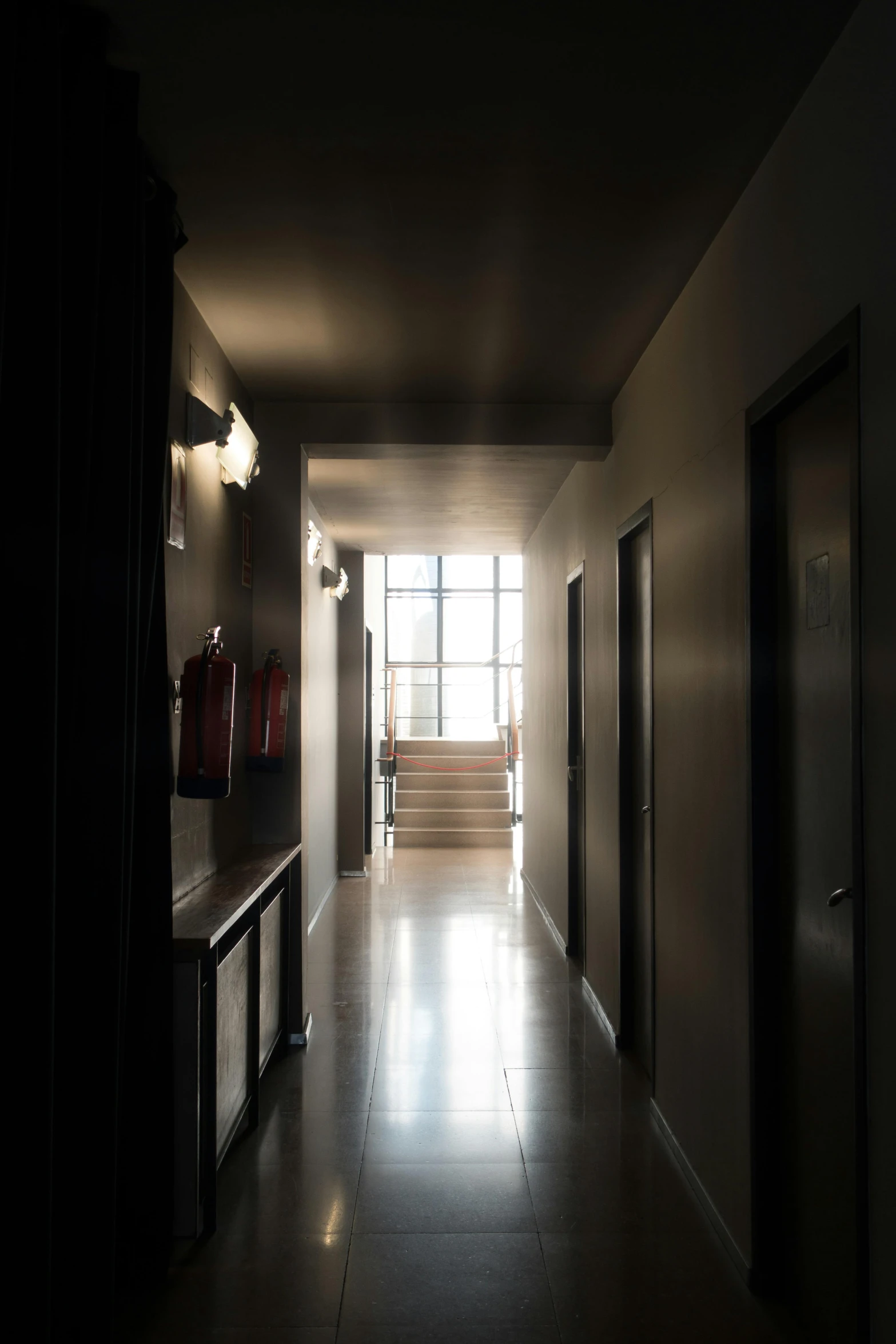 an empty hallway with dark walls and stairs