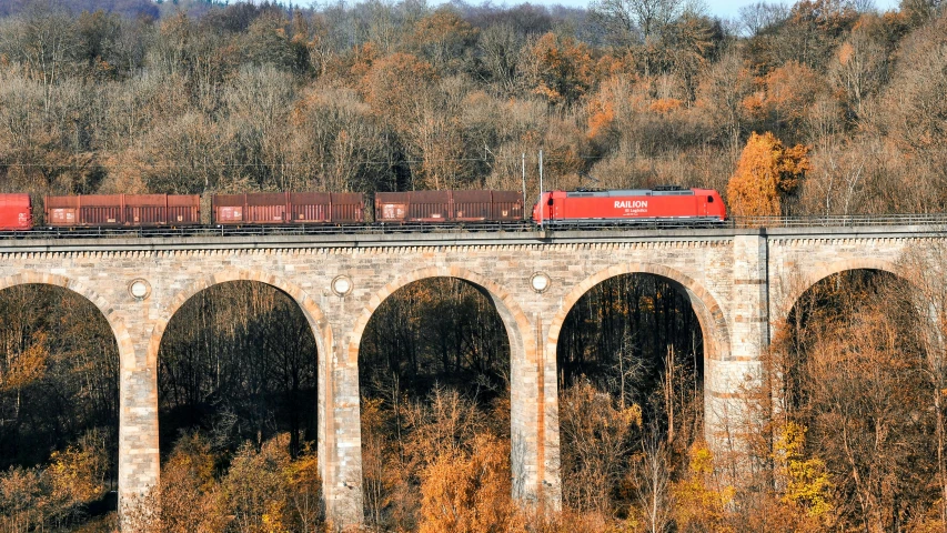 an old bridge with a train traveling over it