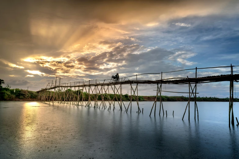 sunset over a bridge across a body of water