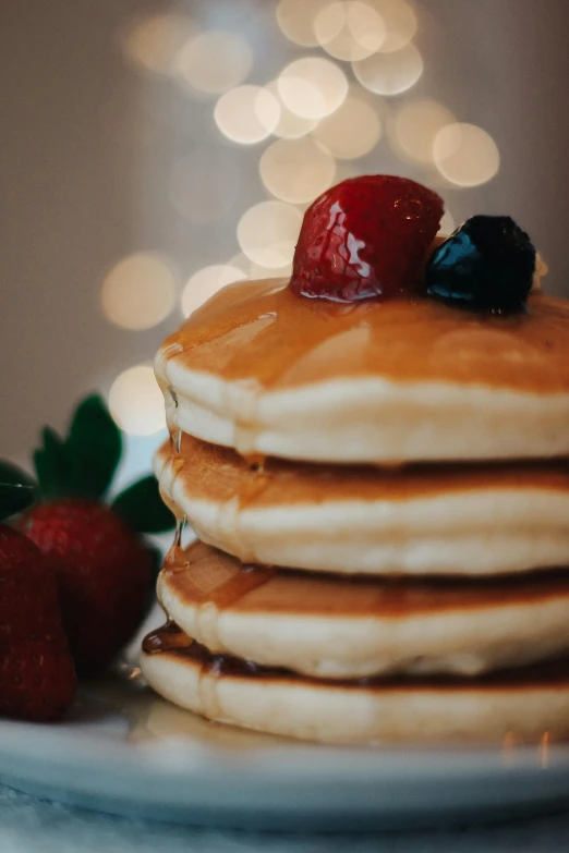 a stack of pancakes topped with syrup and jelly