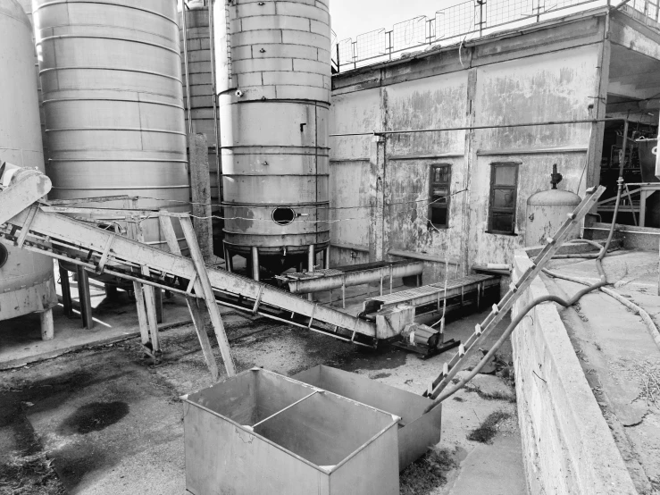 a factory with metal structures and some trees in it