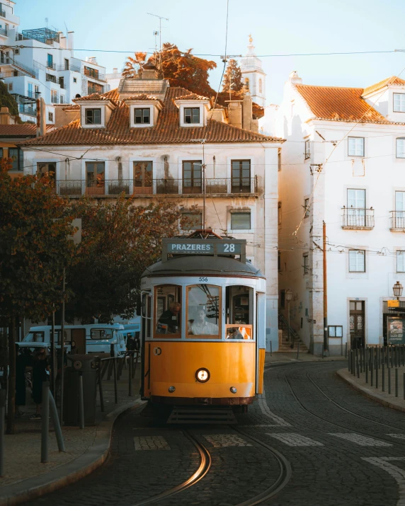 a street car driving through a town near tall buildings