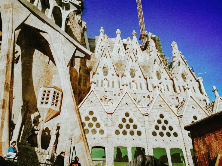 a church with sculptures and people walking by