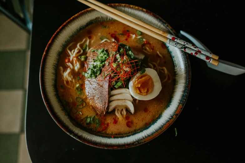 a bowl of soup with chopsticks on top